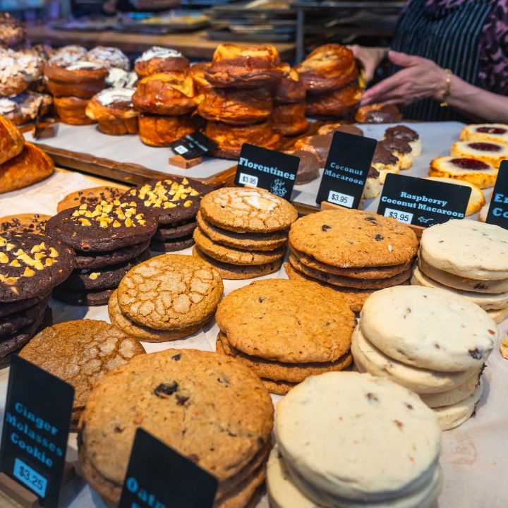 Auslage einer Bäckerei mit Keksen, Plundergebäck und handgeschriebenen Preisschildern