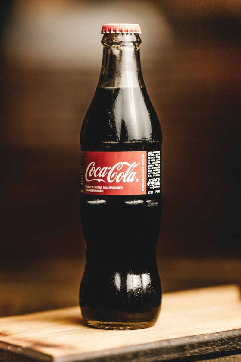 Eine Flasche Cola, die auf einem Holzbrett steht