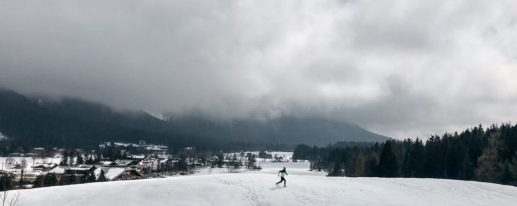 Ultra Läuferin überquert einen schneebedeckten Hügel